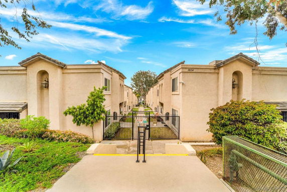 Front view of a residential complex with gated entrance and twin two-story buildings.