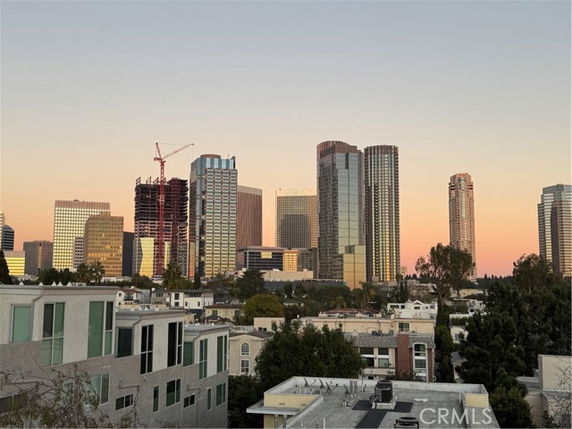 Panoramic view of a city skyline with tall buildings at sunset.