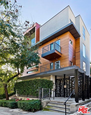 Front view of a modern multi-story building with balconies.