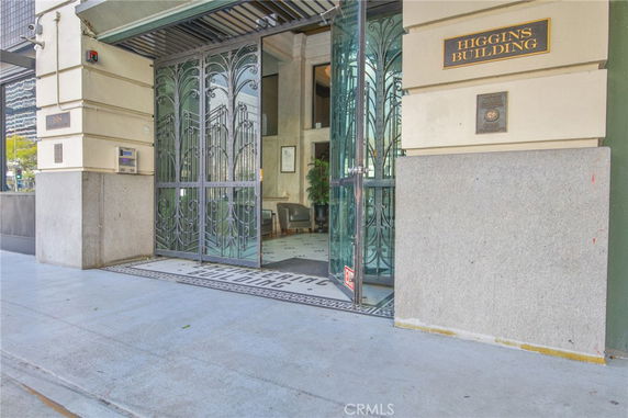 Entrance view of a building with ornate metal doors and the name 'Higgins Building' displayed.