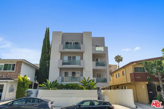 Front view of a multi-story residential building with balconies and modern design.