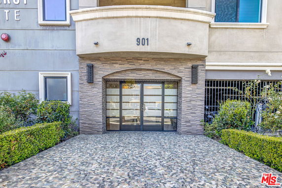 Front view of a modern building entrance with glass doors and brick trim.