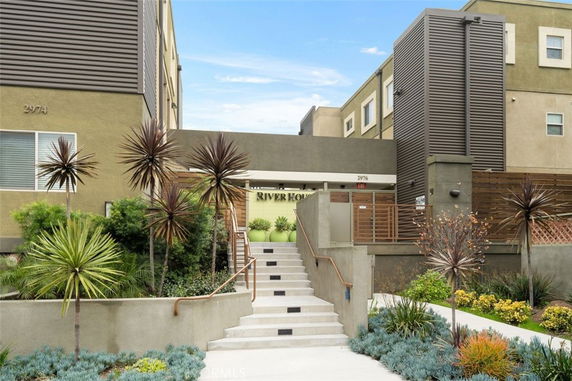 Front view of a multi-story apartment building with modern design and landscaped entrance.