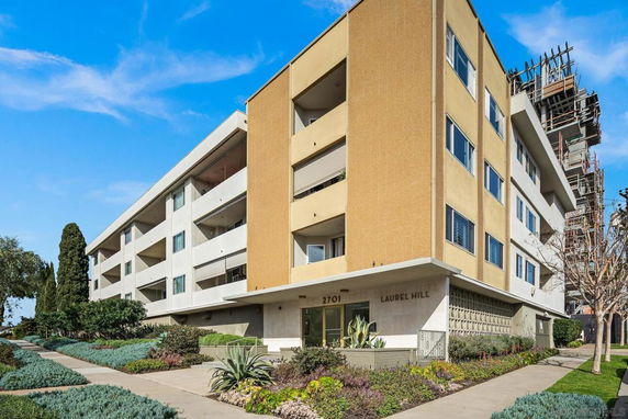 Front view of a multi-story apartment building named 'Laurel Hill' with balconies.