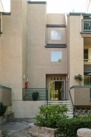 Front view of a multi-story building with a simple facade and entrance steps.