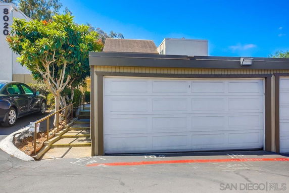 Outdoor parking area with a double garage.