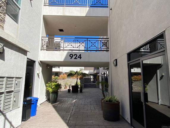View of a modern apartment complex with visible building numbers and potted plants.
