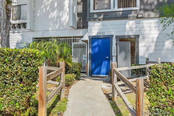 Front view of a building with a blue door and white facade.