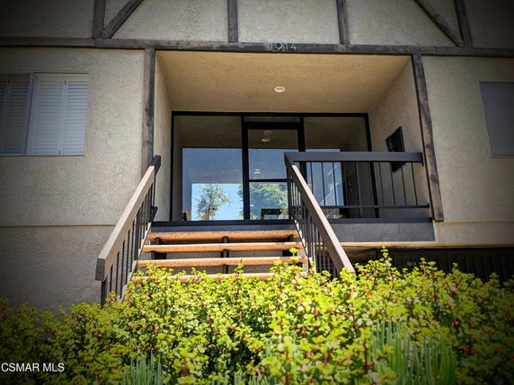 Front view of a building entrance with stairs leading to a covered porch.
