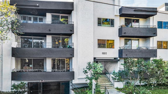 Front view of a multi-story apartment building with balconies.