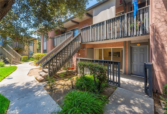 Front view of a two-story residential building with balconies and staircases.