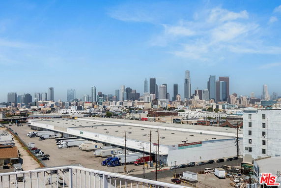 Panoramic view of a city skyline with skyscrapers and industrial buildings.
