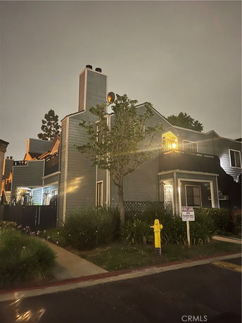 Front view of a multi-story house with chimneys and a small balcony.