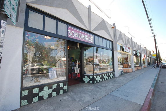 Front view of a commercial building with large glass windows and geometric patterns.