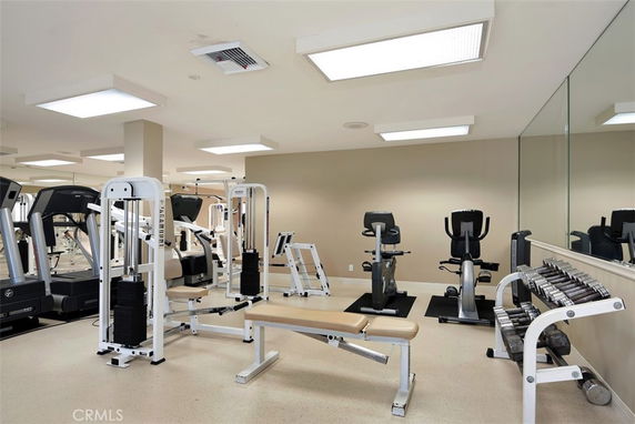 Indoor gym area with exercise machines and weights.