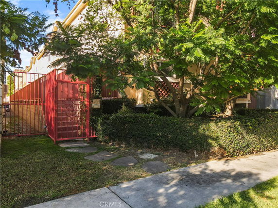 Front view of a house with red fencing and greenery