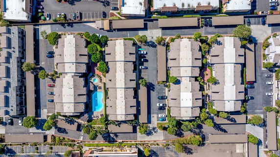 Aerial view of a residential complex with multiple buildings and a central swimming pool.