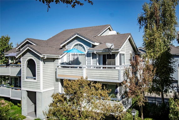 Front view of a two-story house with a balcony and gable roof.