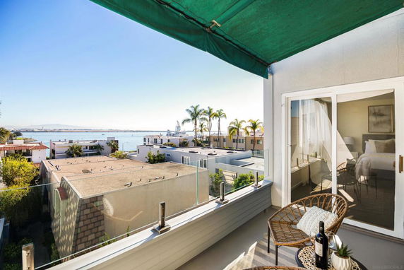 View of rooftops and a waterfront from a balcony.
