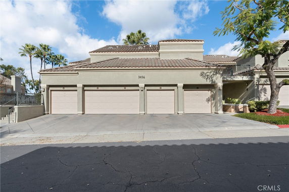 Front view of a residential building with multiple garages and a tile roof.