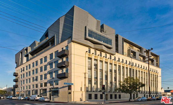 Front view of a multi-story building with a modern design and multiple balconies.