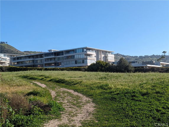 Front view of a modern multi-story building with large glass windows.