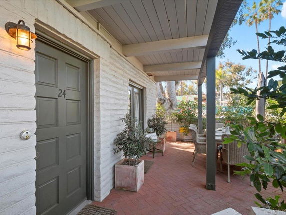 Front view of a house entrance with outdoor seating area.