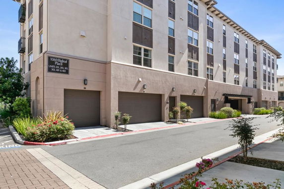 Front view of a multi-story apartment building with garage doors.