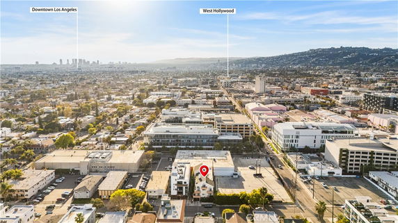 Wide angle aerial view of a cityscape with multiple buildings and a distant skyline.