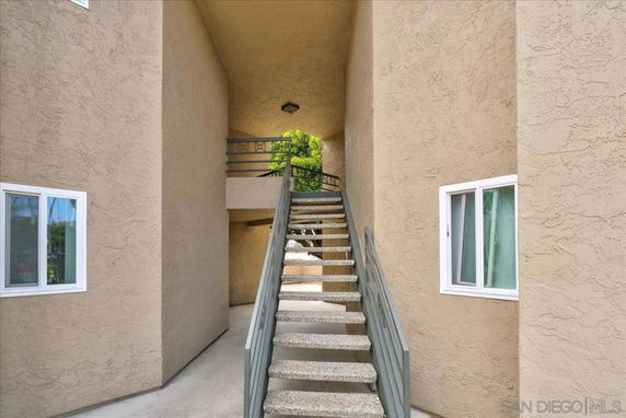 Stairway leading to the entrance of a building with stucco walls.