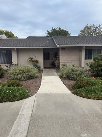Front view of a single-story house with a pathway leading to the entrance.