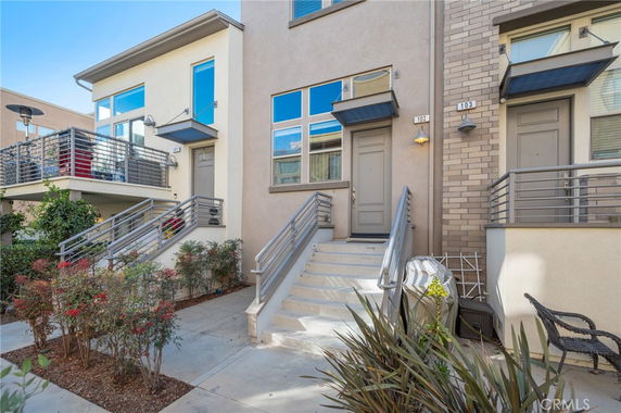 Front view of a modern townhouse with a small staircase leading to the entrance.