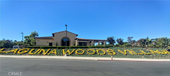 Front view of a building with 'Laguna Woods Village' signage in foreground.