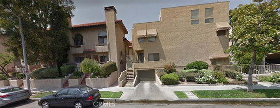 Front view of a multi-story apartment building with underground parking.