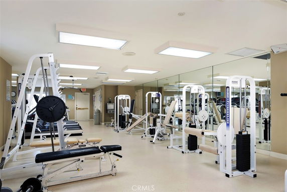 Interior view of a gym with exercise equipment and mirrors.