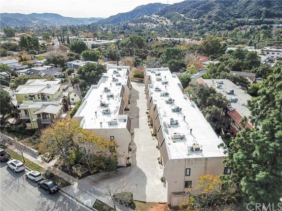 Aerial view of rows of buildings with flat rooftops in a residential area.