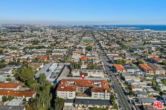 Panoramic view of a suburban area with dense housing and distant cityscape leading to the ocean.
