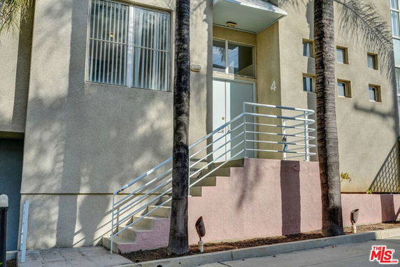 Front view of a building with a staircase leading to an entrance.