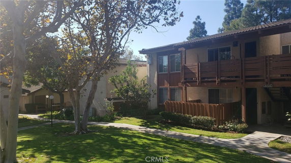 Front view of a two-story residential building with wooden balconies.