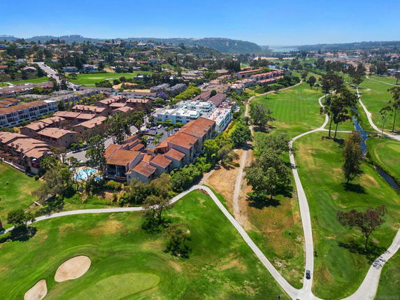 Aerial view of a residential area adjacent to a green golf course.
