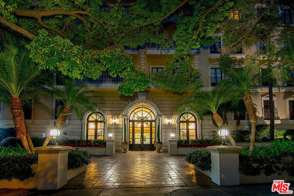 Front view of a multi-story building with arched entrance and decorative lighting.