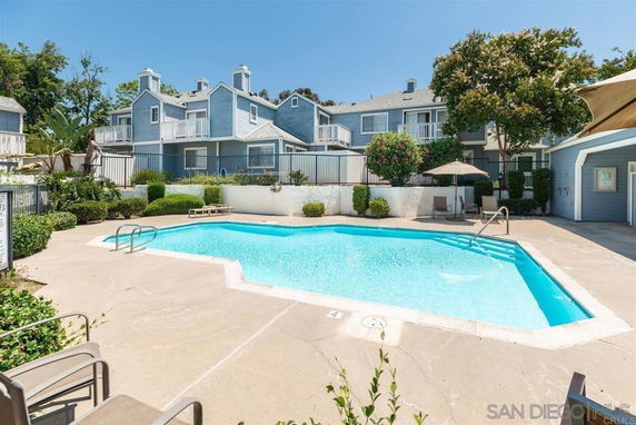 Outdoor area with a swimming pool surrounded by residential buildings.