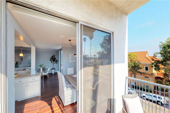 View of surrounding residential area seen from a balcony, adjacent to an interior living space.