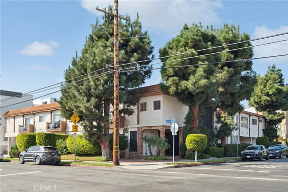 Front view of a multi-story residential building on a street corner.