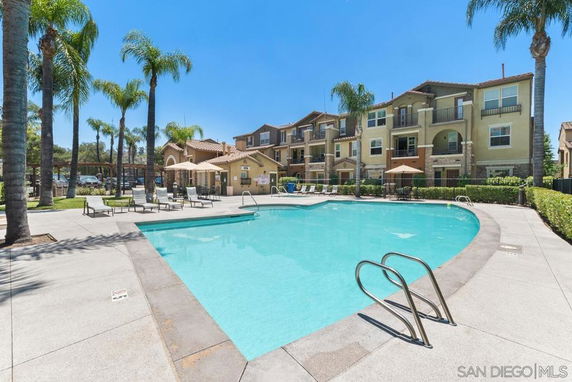 Outdoor swimming pool area with adjacent residential buildings.