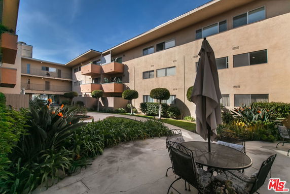 View of a multi-story residential building with balconies and outdoor seating area