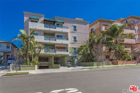 Front view of a multi-story apartment building with balconies.
