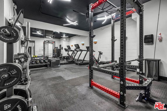 Indoor gym area with exercise equipment, weights, and machines.