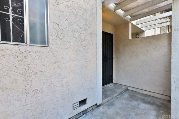 Entry area with a metal door and a window of a building.
