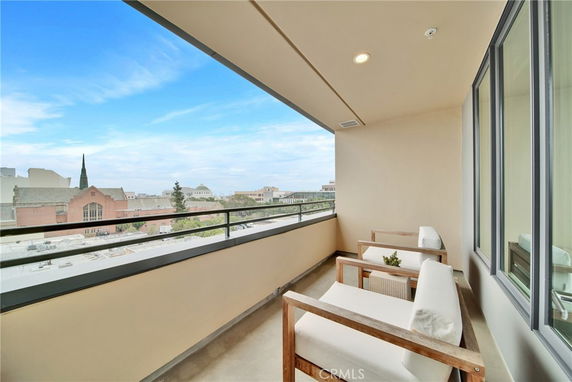 View from a balcony overlooking surrounding buildings with a clear sky.